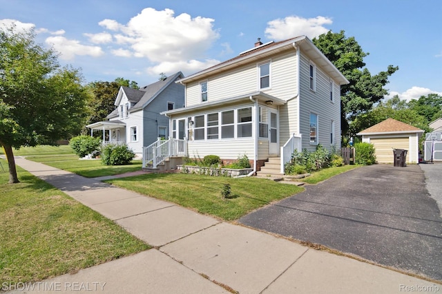 34 Charles St, Hillsdale, MI 49242 - view of front of house with an outdoor structure, a garage, a front lawn, and a chimney
