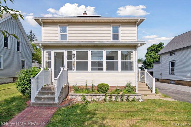 34 Charles St, Hillsdale, MI 49242 - traditional style home with a front lawn and a sunroom
