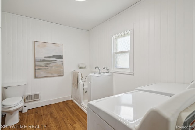 34 Charles St, Hillsdale, MI 49242 - bathroom featuring independent washer and dryer, a bath, wood finished floors, and wooden walls