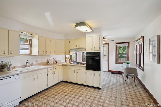 34 Charles St, Hillsdale, MI 49242 - kitchen with white dishwasher, cream cabinets, oven, stainless steel gas cooktop, and under cabinet range hood