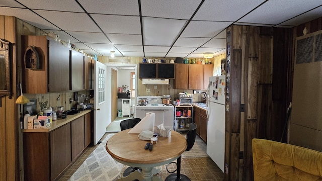 211 Skocelas Rd N, Manistee, MI 49660 - kitchen featuring white appliances, light countertops, a drop ceiling, under cabinet range hood, and a heating unit