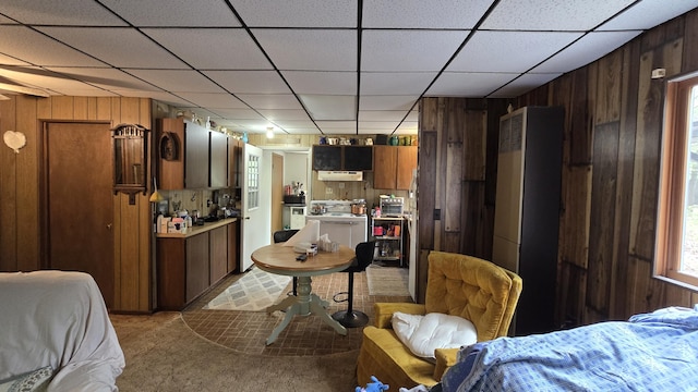 211 Skocelas Rd N, Manistee, MI 49660 - dining space featuring wooden walls, light carpet, and a drop ceiling