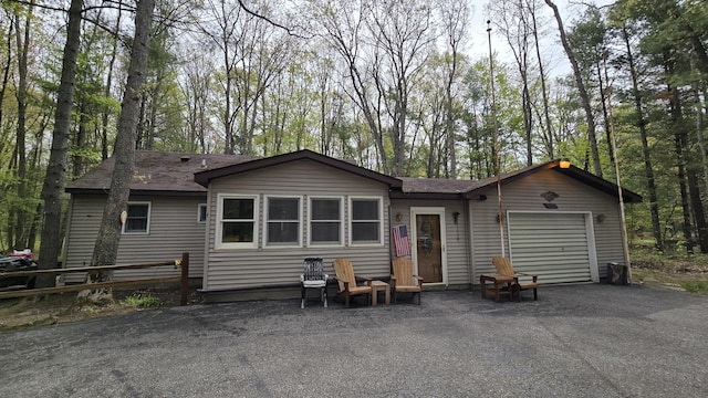 211 Skocelas Rd N, Manistee, MI 49660 - back of property with an attached garage, driveway, and roof with shingles