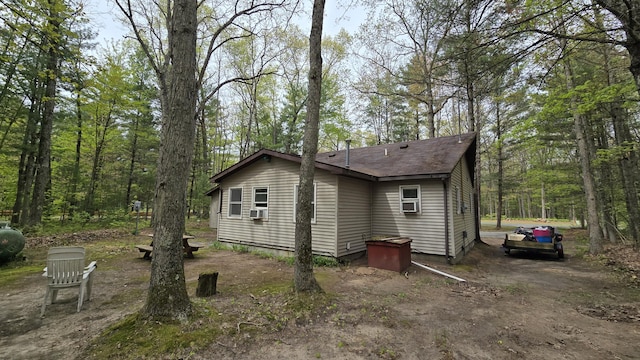 211 Skocelas Rd N, Manistee, MI 49660 - view of home's exterior with cooling unit and a shingled roof