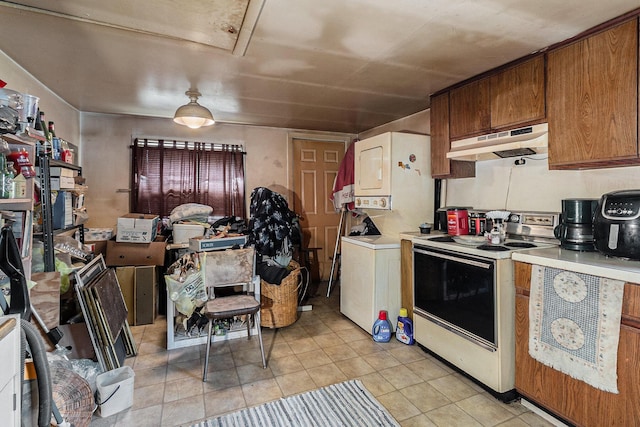 724 E Ludington Ave, Ludington, MI 49431 - kitchen featuring white electric range, under cabinet range hood, light countertops, light tile patterned flooring, and brown cabinets