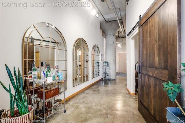 444 W Willis St Unit 211, Detroit, MI 48201 - hallway featuring a towering ceiling, concrete flooring, and a barn door