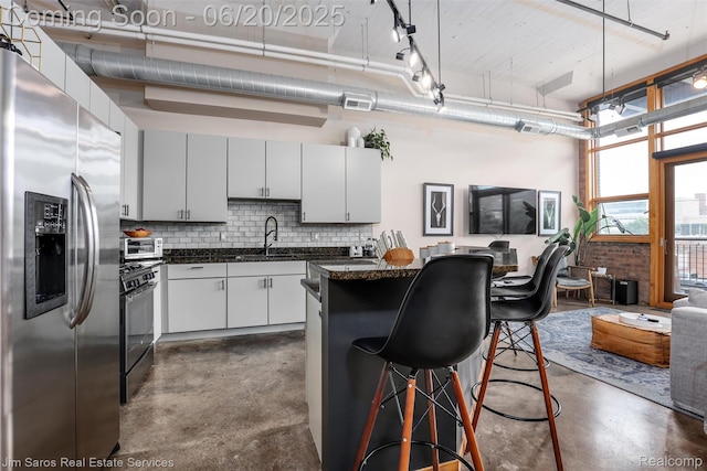 444 W Willis St Unit 211, Detroit, MI 48201 - kitchen with stainless steel fridge, concrete flooring, range with gas stovetop, a kitchen breakfast bar, and a high ceiling