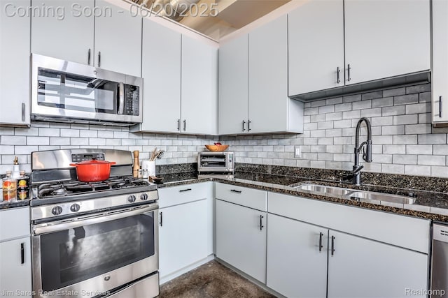 444 W Willis St Unit 211, Detroit, MI 48201 - kitchen featuring appliances with stainless steel finishes, dark stone counters, backsplash, concrete floors, and white cabinetry