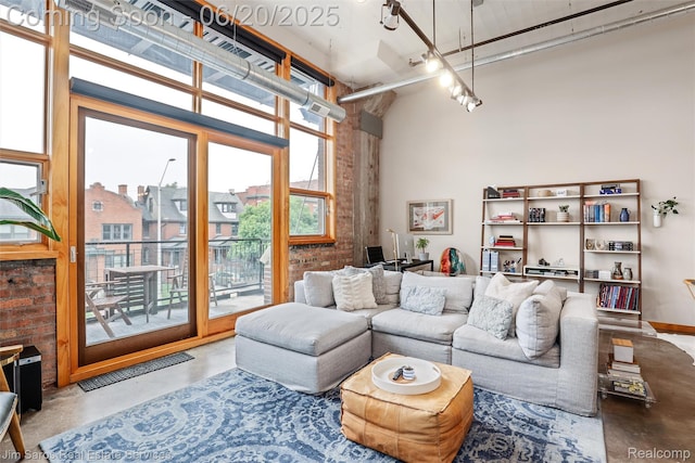 444 W Willis St Unit 211, Detroit, MI 48201 - living area with finished concrete floors, a towering ceiling, and brick wall