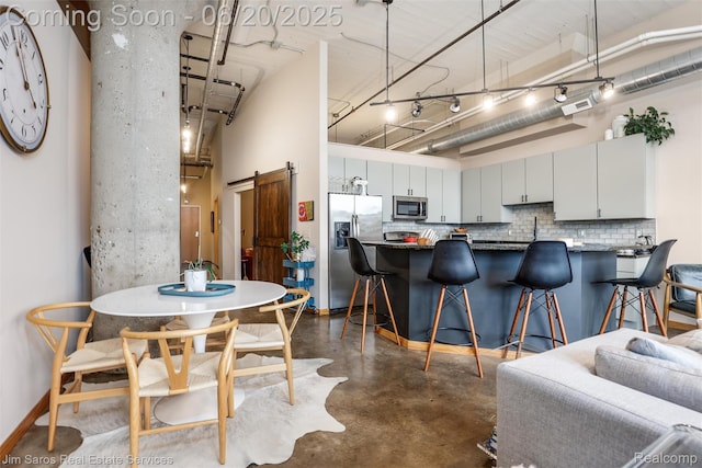 444 W Willis St Unit 211, Detroit, MI 48201 - dining space featuring finished concrete floors, a barn door, and a high ceiling