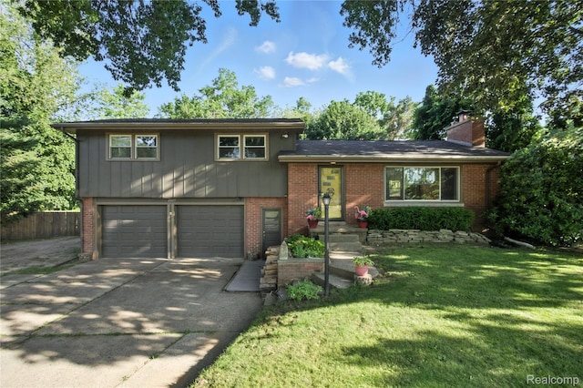 2329 Cumberland Rd, Lansing, MI 48906 - tri-level home featuring brick siding, a garage, driveway, and a chimney