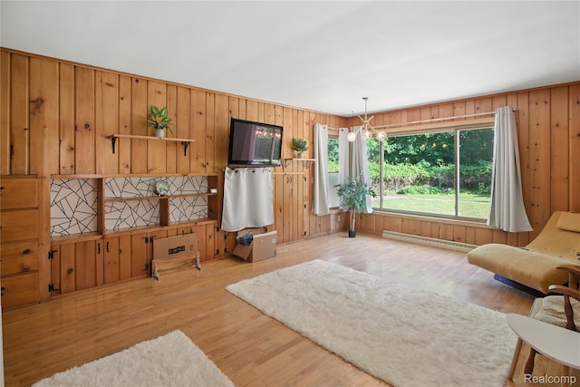 2329 Cumberland Rd, Lansing, MI 48906 - living room featuring a baseboard heating unit, wood finished floors, and wooden walls