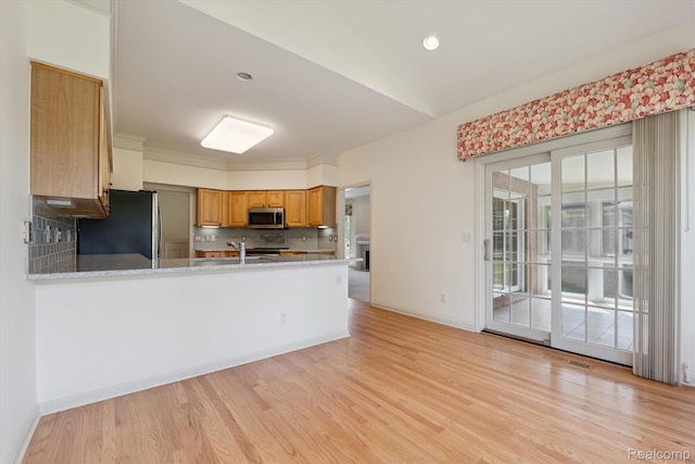 1921 Dunham Dr, Rochester, MI 48306 - kitchen featuring stainless steel appliances, decorative backsplash, light wood finished floors, a peninsula, and brown cabinetry