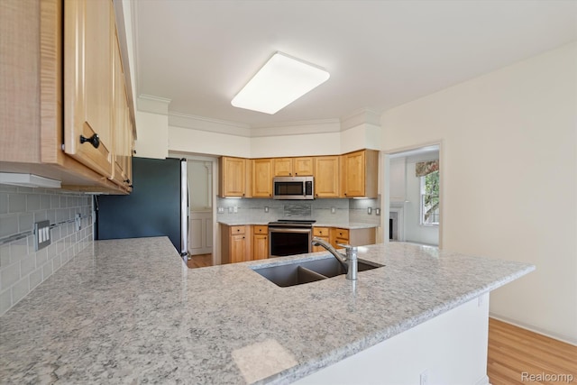 1921 Dunham Dr, Rochester, MI 48306 - kitchen featuring appliances with stainless steel finishes, tasteful backsplash, a peninsula, light stone counters, and light wood finished floors