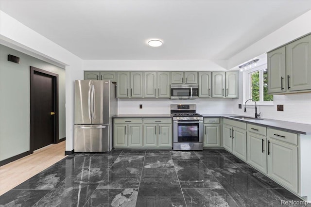 12115 Newburgh Rd, Livonia, MI 48150 - kitchen featuring appliances with stainless steel finishes, backsplash, green cabinets, and gray cabinetry
