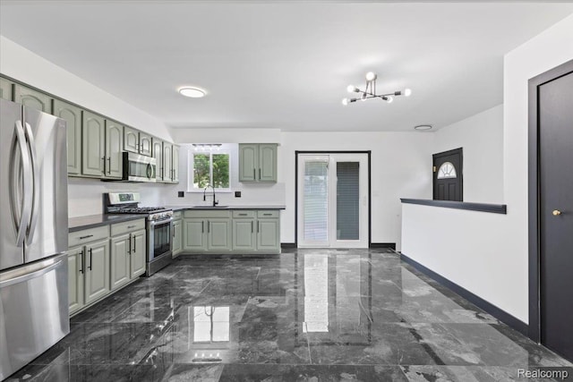 12115 Newburgh Rd, Livonia, MI 48150 - kitchen with stainless steel appliances, dark marble finish floors, green cabinets, and a chandelier