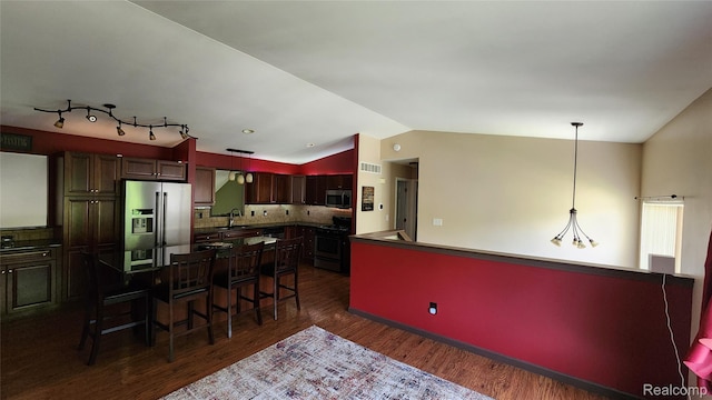 29390 Juniper St, Trenton, MI 48183 - kitchen with stainless steel appliances, lofted ceiling, dark wood-style flooring, a kitchen breakfast bar, and tasteful backsplash