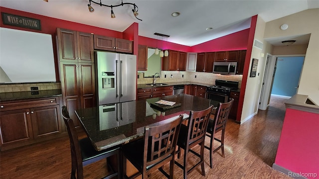 29390 Juniper St, Trenton, MI 48183 - kitchen featuring appliances with stainless steel finishes, lofted ceiling, tasteful backsplash, dark wood-style flooring, and a kitchen breakfast bar