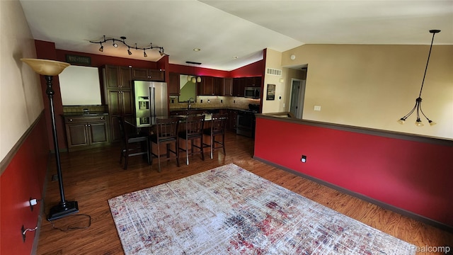 29390 Juniper St, Trenton, MI 48183 - kitchen with stainless steel appliances, dark wood finished floors, a kitchen breakfast bar, lofted ceiling, and dark countertops