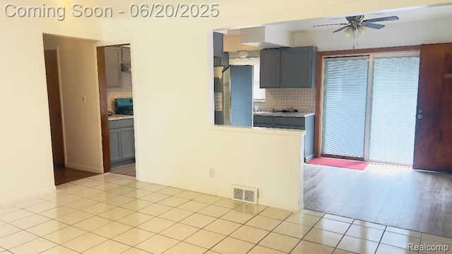 23930 Eureka Ave, Warren, MI 48091 - kitchen with refrigerator, gray cabinets, ceiling fan, and decorative backsplash
