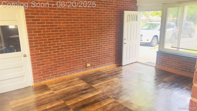 23930 Eureka Ave, Warren, MI 48091 - empty room with brick wall and wood finished floors