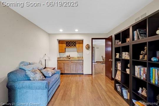7190 Pebble Park Dr, West Bloomfield, MI 48322 - sitting room featuring bar with sink, light wood-style floors, and recessed lighting