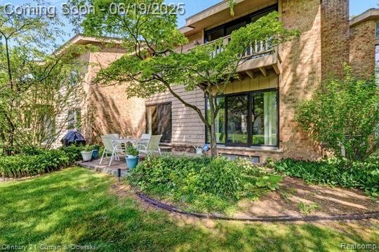 7190 Pebble Park Dr, West Bloomfield, MI 48322 - rear view of house featuring a balcony, a patio, a lawn, and a chimney