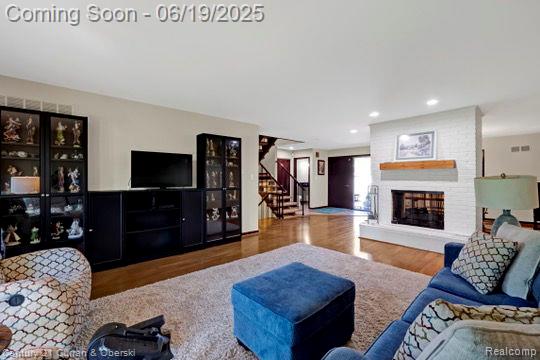 7190 Pebble Park Dr, West Bloomfield, MI 48322 - living room with wood finished floors, stairway, a fireplace, and recessed lighting