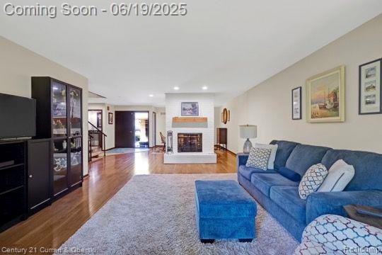 7190 Pebble Park Dr, West Bloomfield, MI 48322 - living room featuring wood finished floors, a fireplace with raised hearth, and recessed lighting