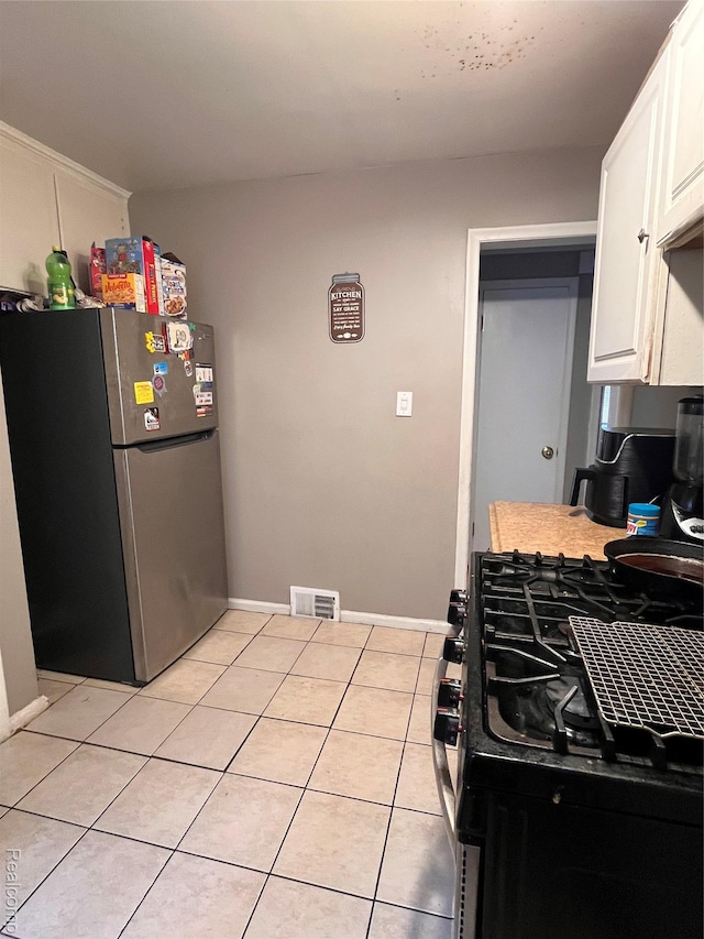 21421 Bournemouth St, Taylor, MI 48225 - kitchen featuring freestanding refrigerator, range with gas cooktop, white cabinets, and light tile patterned flooring