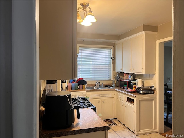 21421 Bournemouth St, Taylor, MI 48225 - kitchen featuring light tile patterned floors, black gas stove, white cabinetry, and a chandelier