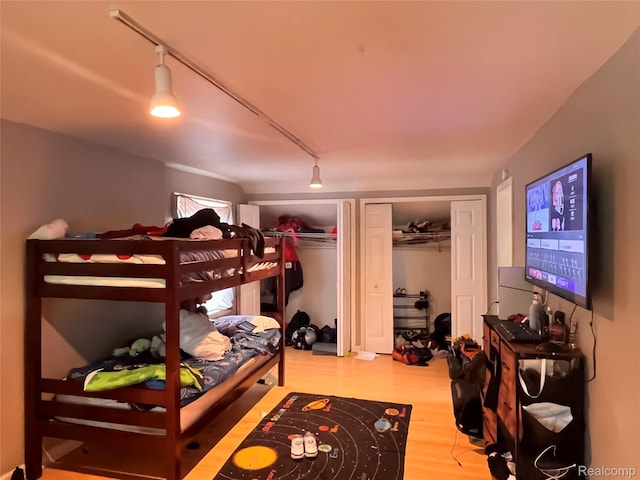21421 Bournemouth St, Taylor, MI 48225 - bedroom featuring rail lighting, wood finished floors, and two closets