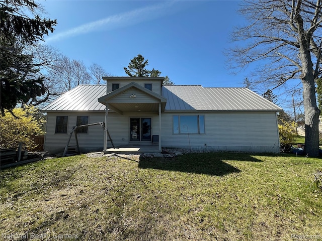 1390 N US-23, East Tawas, MI 48730 - view of front of home featuring a metal roof, a front yard, and a patio area