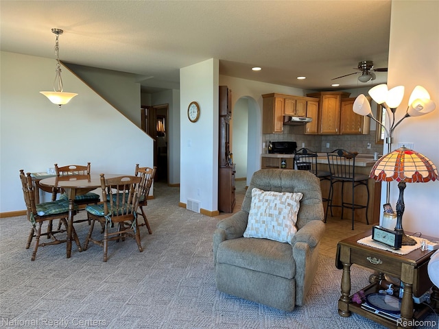 1390 N US-23, East Tawas, MI 48730 - dining room with light carpet, ceiling fan, arched walkways, and recessed lighting