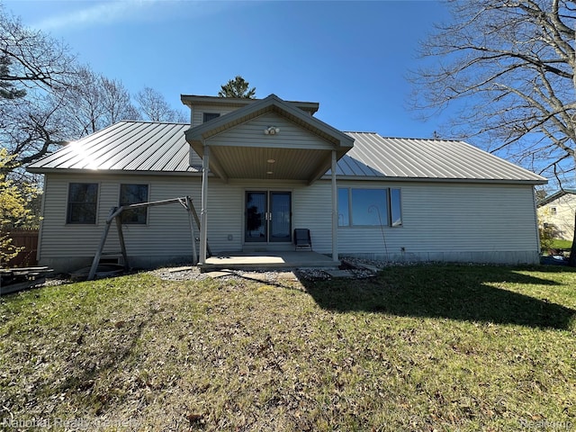 1390 N US-23, East Tawas, MI 48730 - rear view of house featuring a metal roof, a yard, a patio, and a standing seam roof