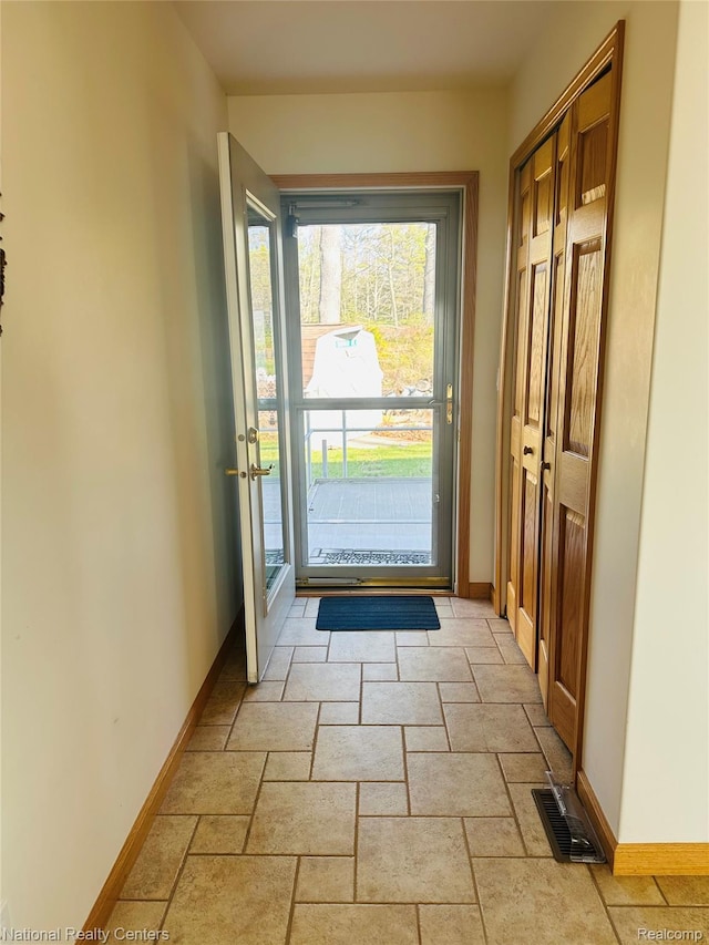 1390 N US-23, East Tawas, MI 48730 - doorway to outside featuring baseboards and stone tile floors