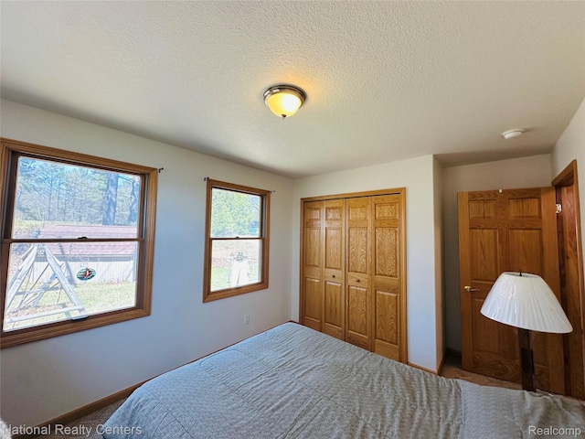 1390 N US-23, East Tawas, MI 48730 - carpeted bedroom with a closet and a textured ceiling