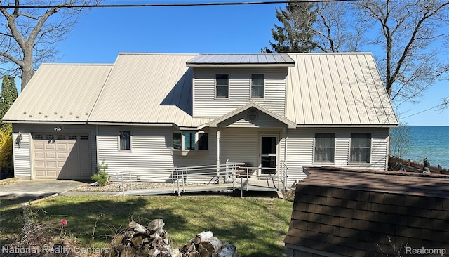 1390 N US-23, East Tawas, MI 48730 - view of front of home featuring a metal roof, a front lawn, an attached garage, and a water view