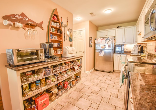 61626 Colony Bay Dr Unit 15, Cassopolis, MI 49031 - kitchen with appliances with stainless steel finishes, white cabinetry, decorative backsplash, and open shelves