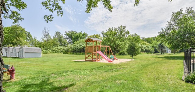 61626 Colony Bay Dr Unit 15, Cassopolis, MI 49031 - view of green lawn with a playground, a storage shed, and view of wooded area