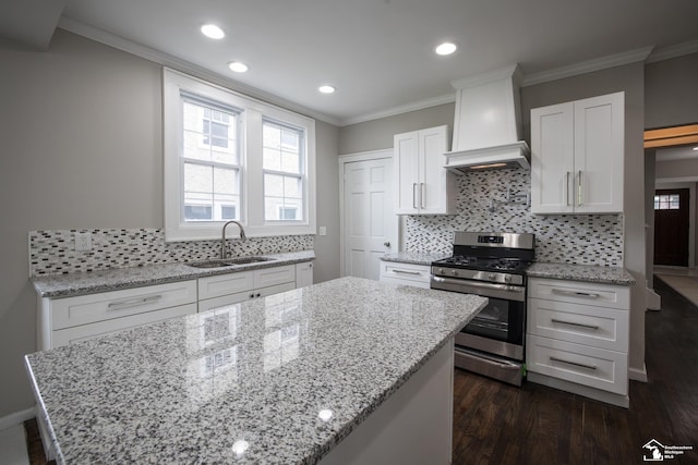 901 Chicago Blvd, Detroit, MI 48202 - kitchen featuring gas range, a kitchen island, dark wood finished floors, light stone counters, and white cabinets