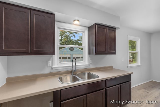 1372 Brookmark St SE, Kentwood, MI 49508 - kitchen with dark brown cabinetry, light countertops, and light wood-style flooring