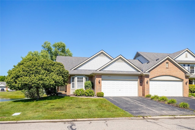 5959 Augusta Ln Unit 20, Grand Blanc, MI 48439 - view of front facade featuring an attached garage, brick siding, asphalt driveway, a front lawn, and a water view