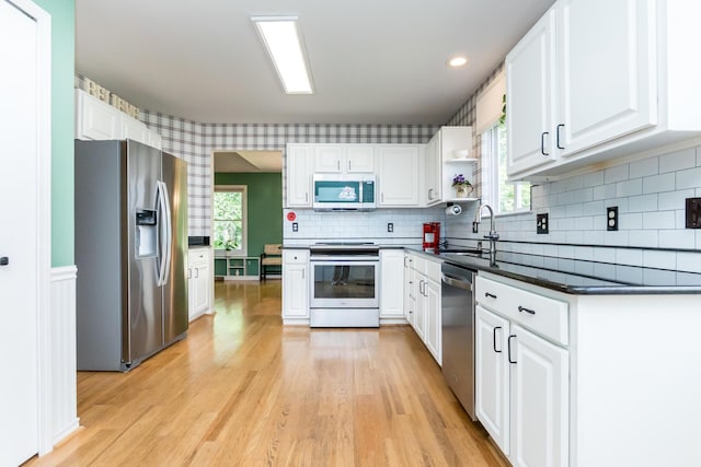 3105 Earlmoore Ln, Ann Arbor, MI 48105 - kitchen featuring appliances with stainless steel finishes, dark countertops, light wood-style flooring, white cabinetry, and recessed lighting