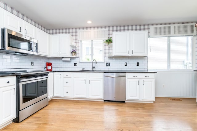 3105 Earlmoore Ln, Ann Arbor, MI 48105 - kitchen with appliances with stainless steel finishes, dark countertops, light wood-style floors, tasteful backsplash, and recessed lighting
