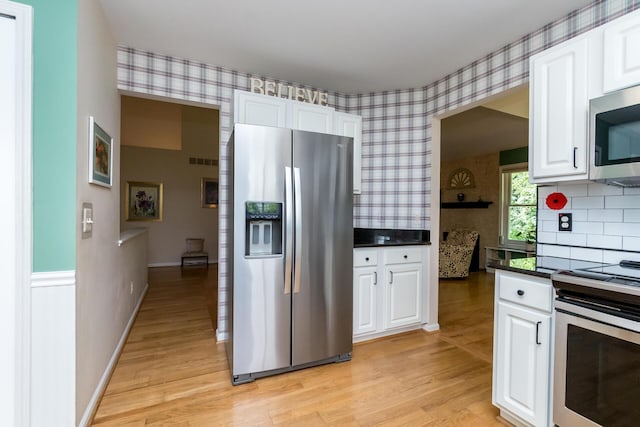 3105 Earlmoore Ln, Ann Arbor, MI 48105 - kitchen featuring stainless steel appliances, wallpapered walls, light wood-style floors, and white cabinetry