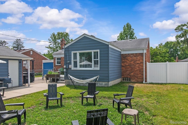 29948 Hathaway St, Livonia, MI 48150 - rear view of house with brick siding, a fire pit, a chimney, and a patio