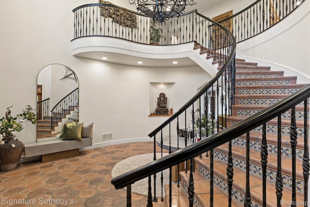597 Yarboro Dr, Bloomfield Hills, MI 48304 - staircase with a towering ceiling, stone finish flooring, a chandelier, and recessed lighting