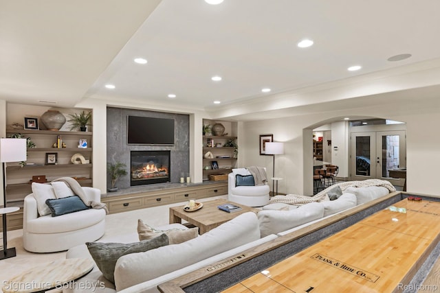 597 Yarboro Dr, Bloomfield Hills, MI 48304 - living room featuring arched walkways, built in shelves, ornamental molding, recessed lighting, and a high end fireplace
