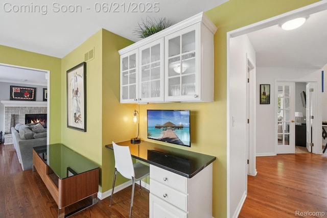 21898 Aspen Ct, Farmington Hills, MI 48335 - office area featuring dark wood finished floors, a fireplace, and built in study area